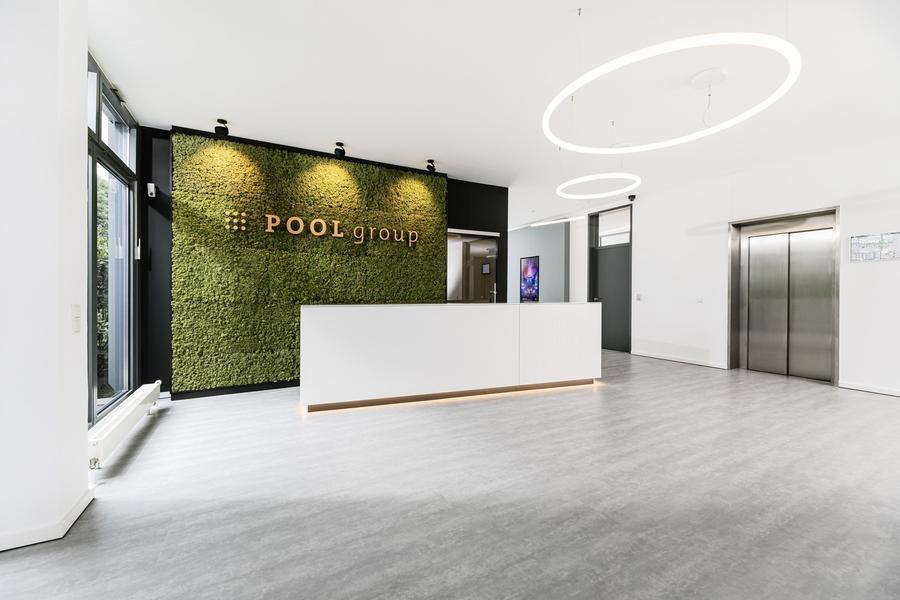 Unternehmenssitz Empfang — Foyer mit grüner Moos-Wand und reduziertem Innenausbau